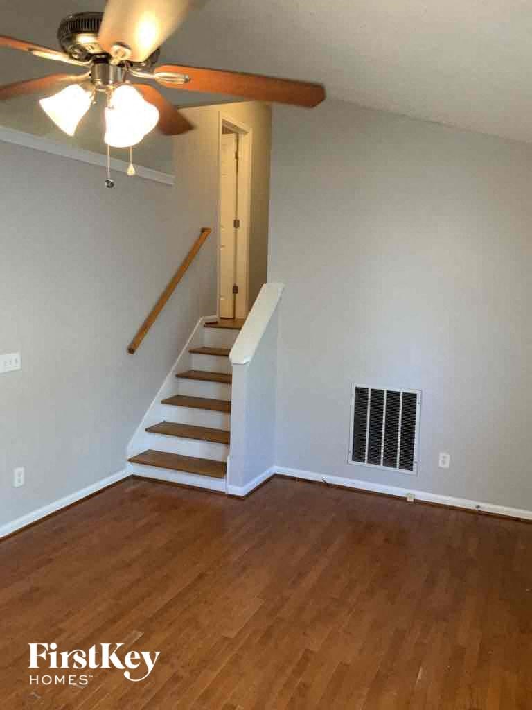 A room with a staircase and a ceiling fan.