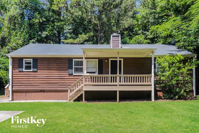 a small house with a porch on a lawn