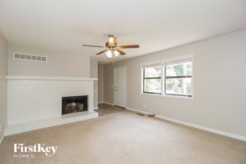 a living room with a ceiling fan and a fireplace