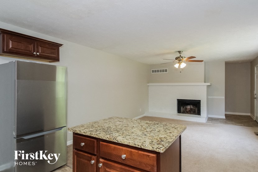 an empty kitchen with a refrigerator and a fireplace