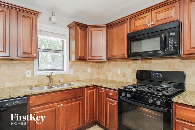a kitchen with wood cabinets and a black stove and a microwave