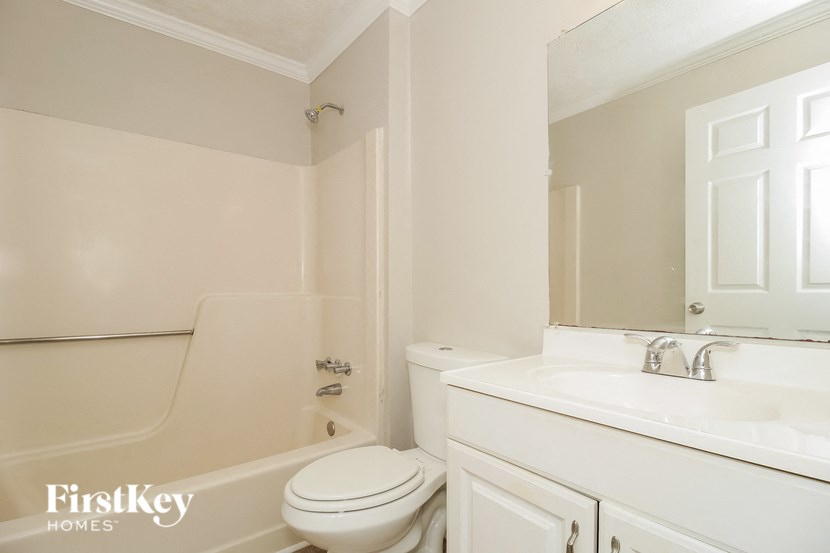 a white bathroom with a toilet and a sink