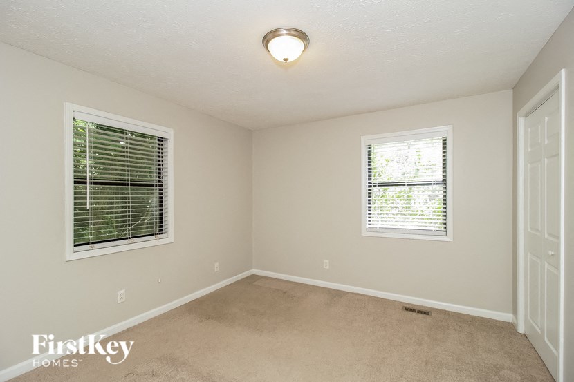 an empty room with two windows and a door
