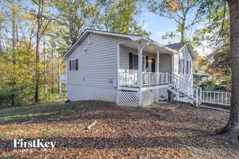 a white house with a white porch and trees