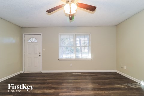 the living room of an empty house with a ceiling fan