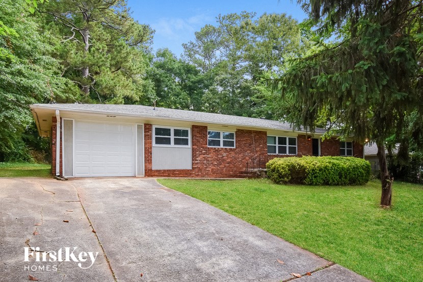 a small brick house with a white garage door