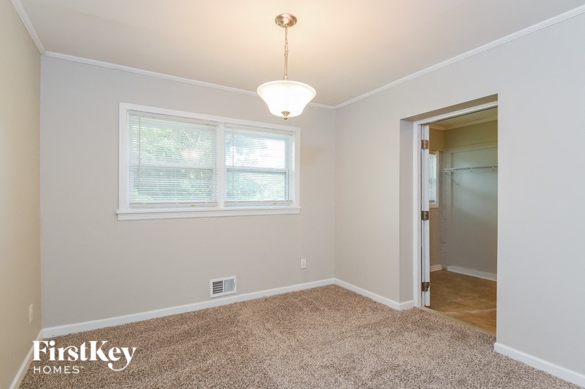 a bedroom with a large window and a door to a closet