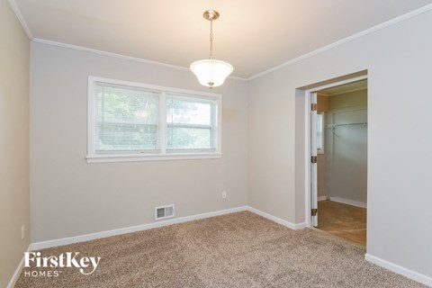a bedroom with a large window and a door to a closet