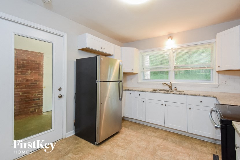 a kitchen with white cabinets and a stainless steel refrigerator