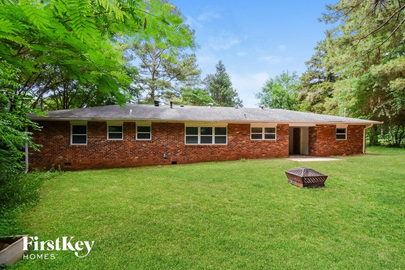 a brick house with a grass yard and a grill