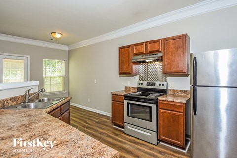 A kitchen with wooden cabinets and a stainless steel refrigerator.