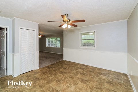 the living room and dining room of a house with a ceiling fan