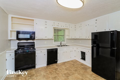 a kitchen with black appliances and white cabinets