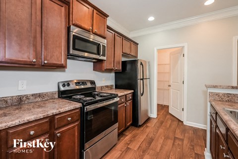 A kitchen with wooden cabinets and a black refrigerator.