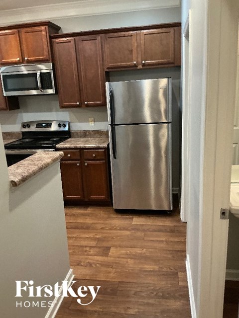 A kitchen with wooden cabinets and a stainless steel refrigerator.