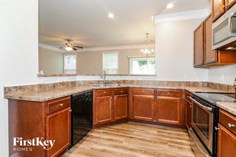 A kitchen with wooden cabinets and a granite countertop.