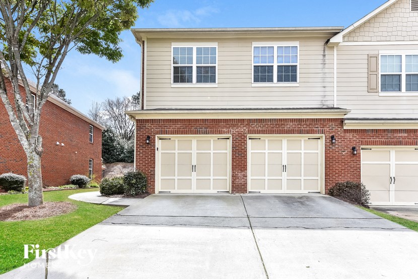 a white garage door in front of a brick house
