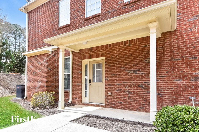 the front entrance of a brick house with a yellow door
