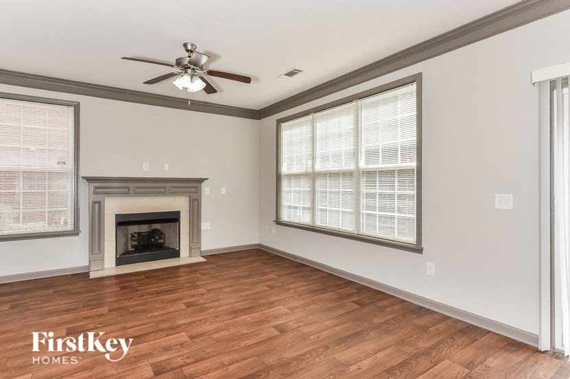 a living room with a fireplace and a ceiling fan