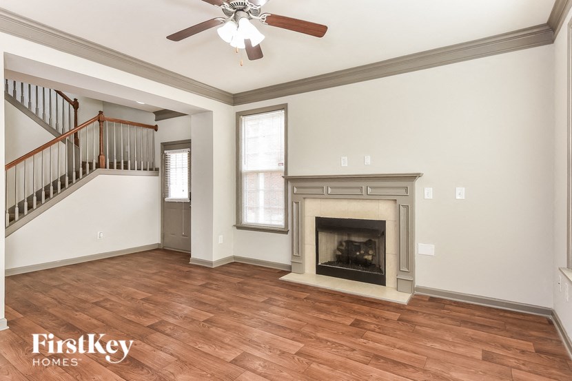 an empty living room with a fireplace and a staircase