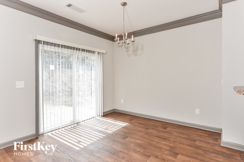 an empty living room with a sliding glass door to a patio