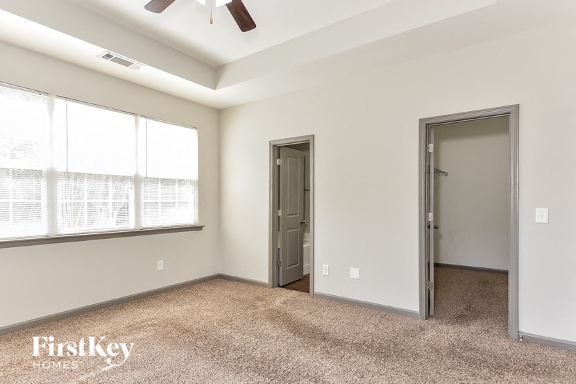 a bedroom with a large window and a door to a closet