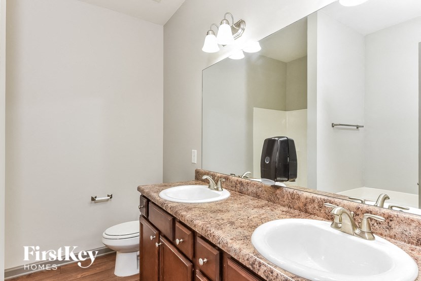 a bathroom with two sinks and a toilet and a mirror