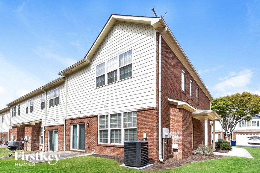 a white and brick house with a blue sky