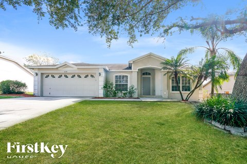 a house with a lawn and palm trees