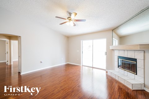 a living room with a fireplace and a ceiling fan