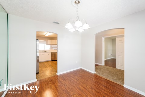 a renovated living room with wood flooring and a kitchen