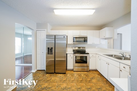 a renovated kitchen with stainless steel appliances and white cabinets