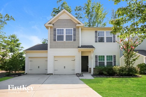 the front of a white house with a driveway