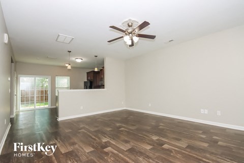 an empty living room with a ceiling fan