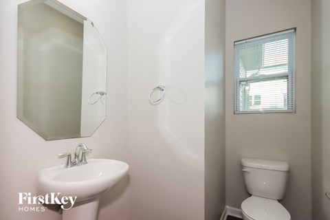 a bathroom with a toilet and a sink and a mirror