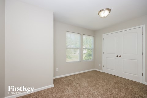 a bedroom with a door and a window and carpeted floor