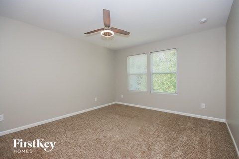 an empty room with a ceiling fan and a window