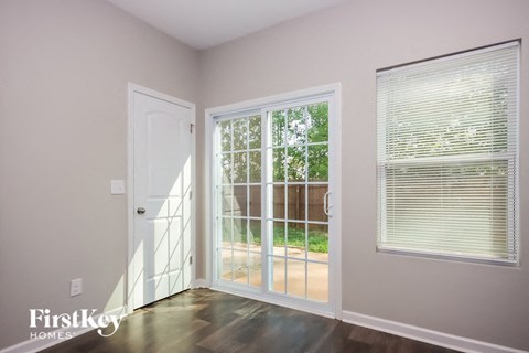 a living room with a door to a patio     and a window