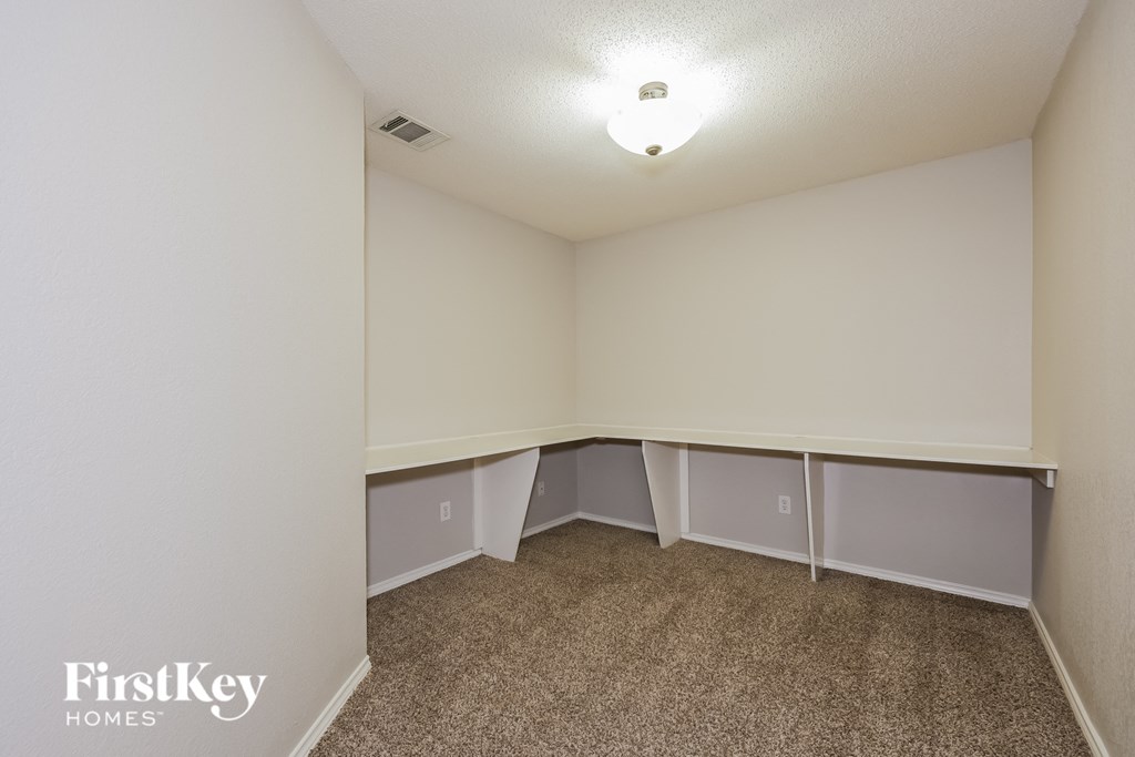 A carpeted room with a FirstKey Homes logo.