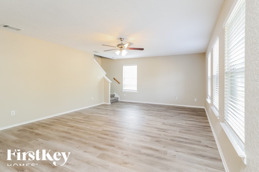 A spacious room with a ceiling fan and wooden flooring.