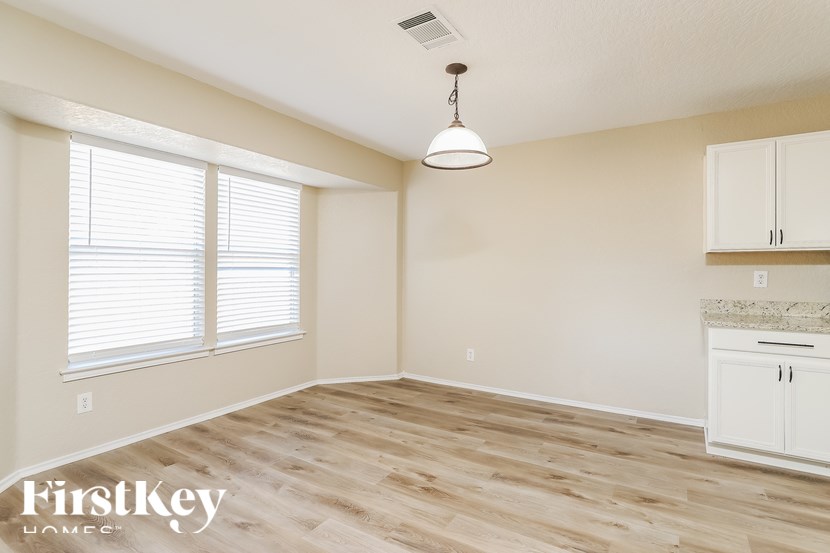 A room with wooden flooring and a hanging light fixture.