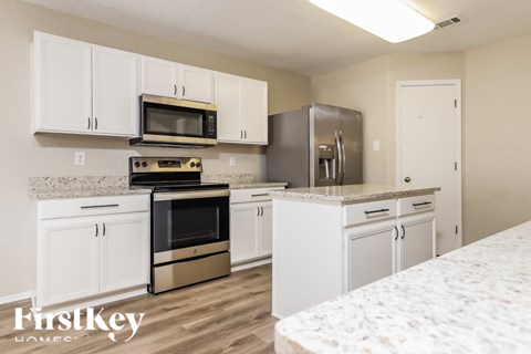 A kitchen with white cabinets and appliances.