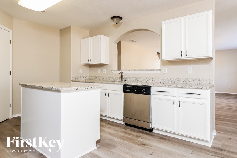 A kitchen with white cabinets and a stainless steel dishwasher.