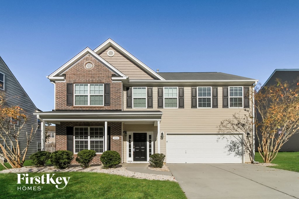 A house with a garage and a driveway in front of it.