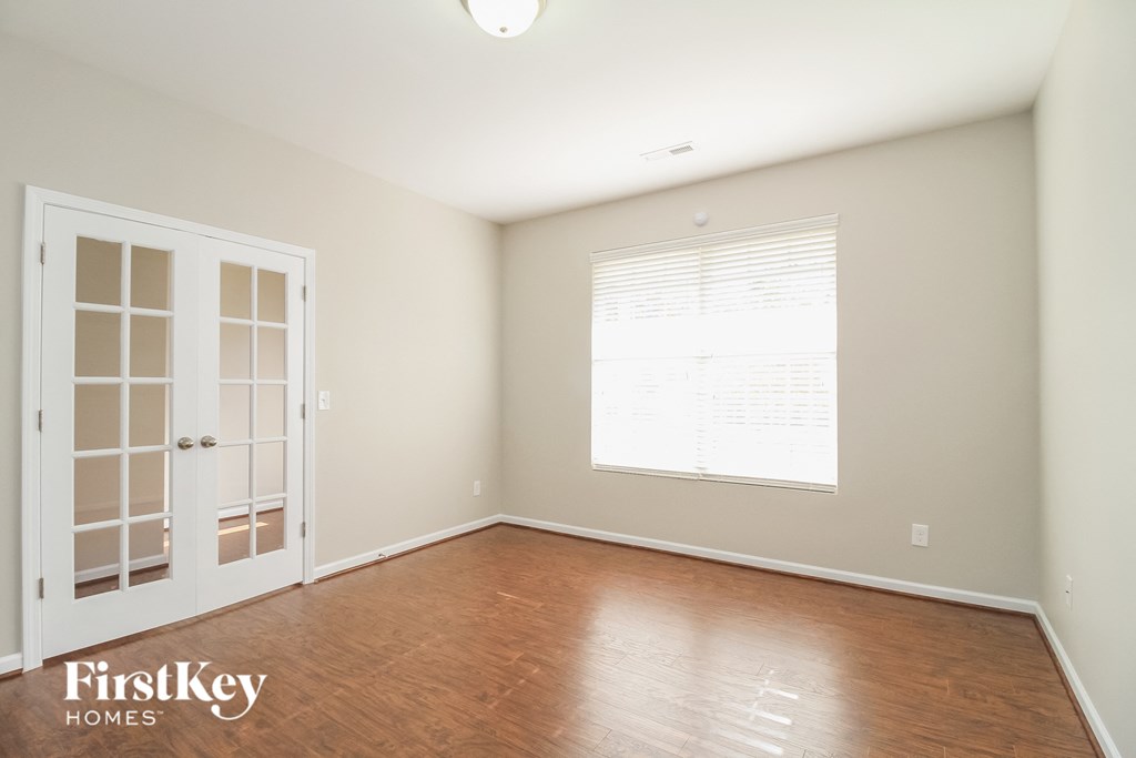 A room with a white door and a window with blinds.