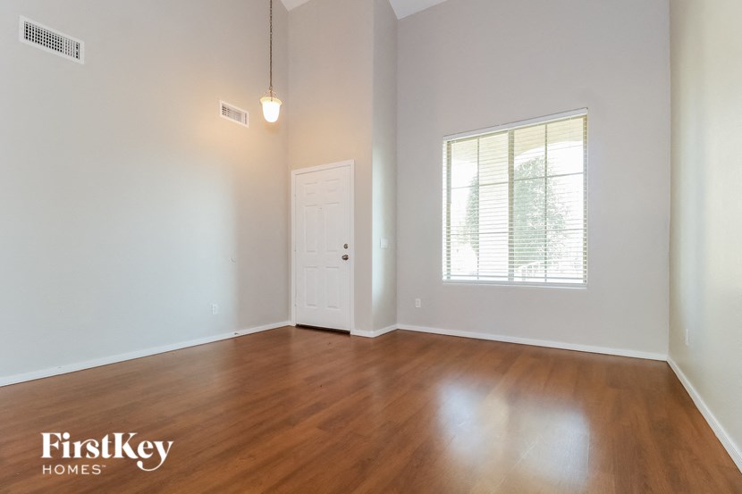an empty living room with wood floors and a white door