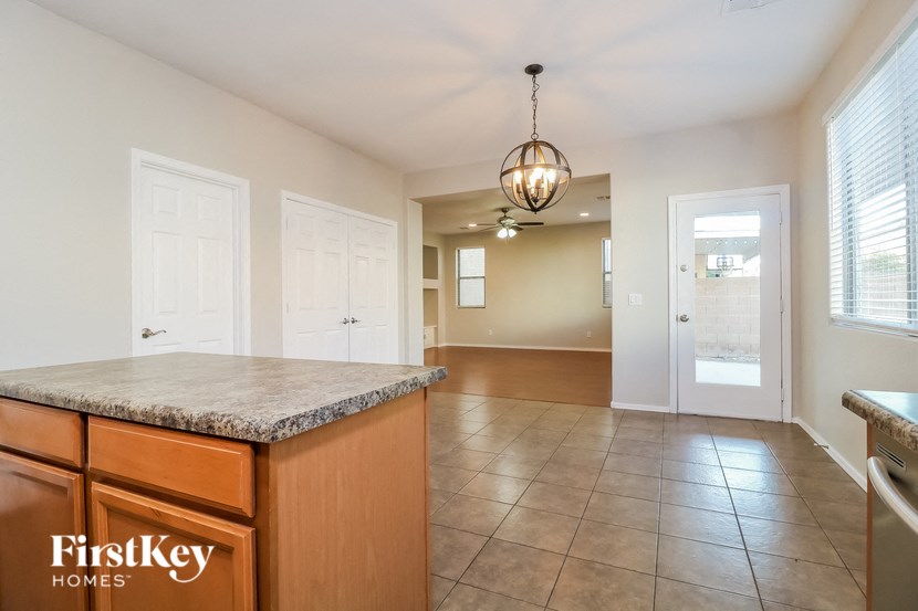 a kitchen with a counter top and a hallway with a door to a house