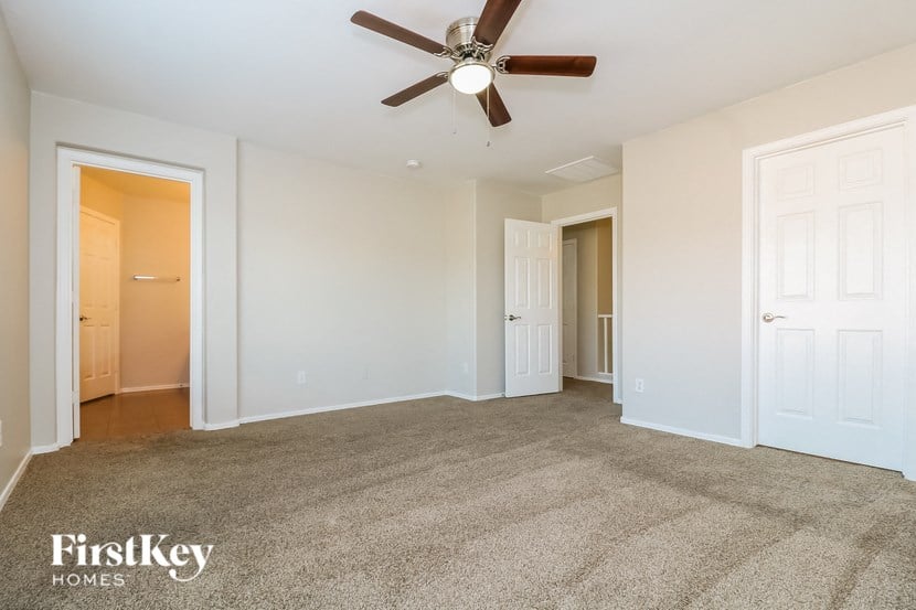 a living room with carpet and a ceiling fan