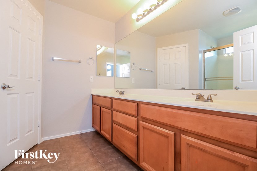 the master bathroom has a large vanity and a large mirror