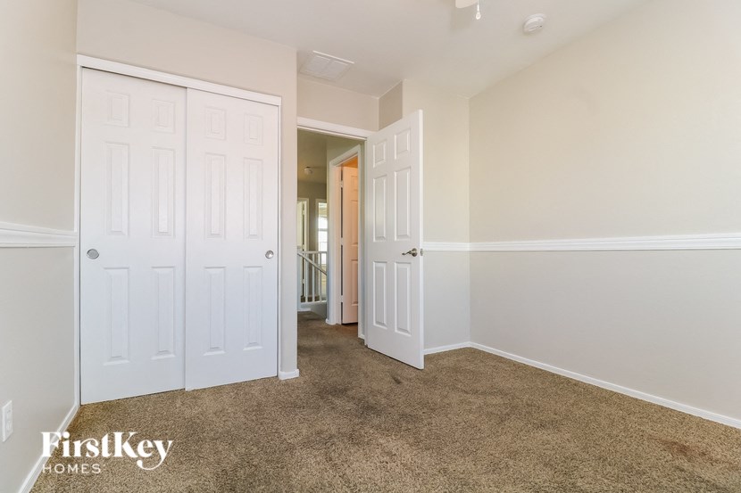 a bedroom with two closets and a carpeted floor